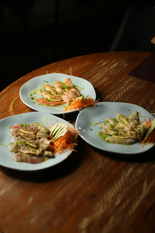 three plates sit on a wooden table