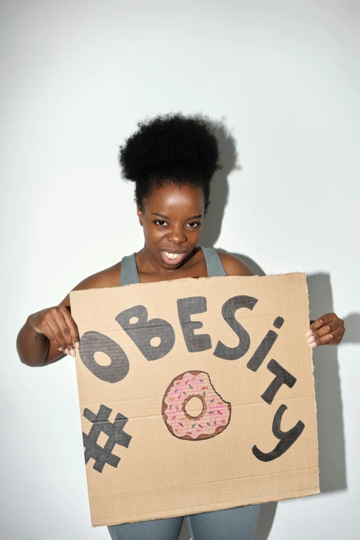woman holding sign reading bespect with doughnuts on it
