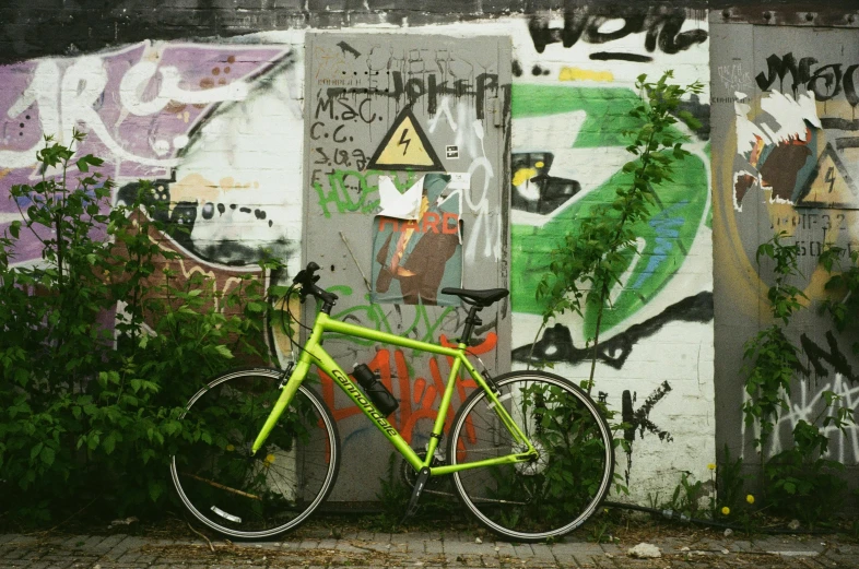 a green bike next to some colorful painted wall