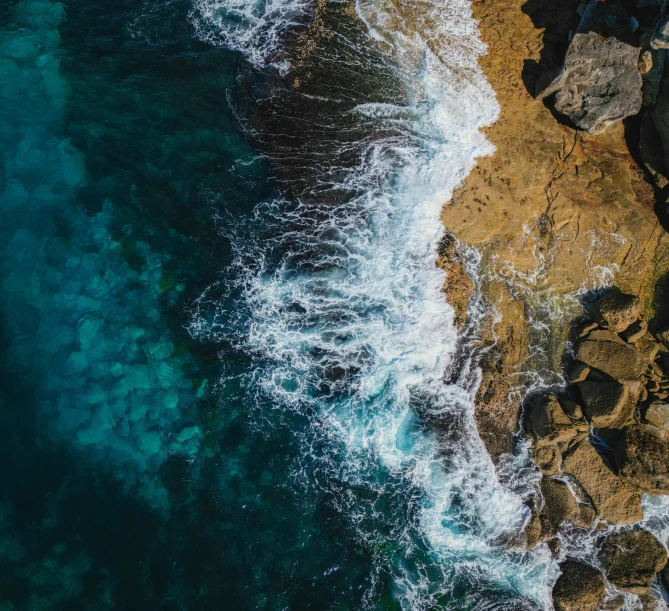 an aerial view of some rocks next to the ocean