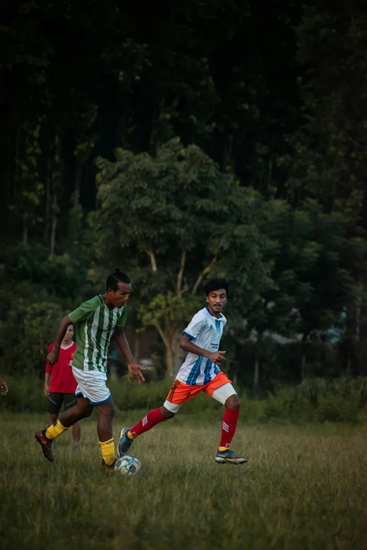 two men playing soccer together in a field