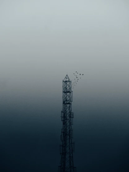 birds are flying near a tall metal structure