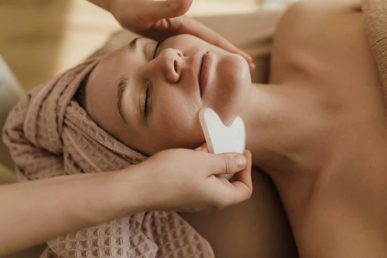 a woman is laying on her side having a facial clean