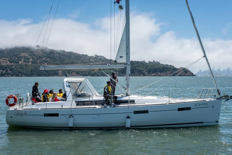 people stand on a sailboat out in the ocean