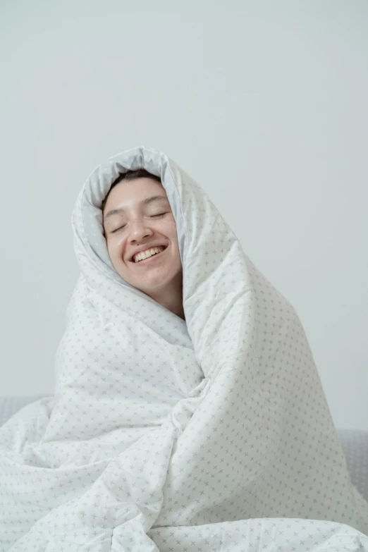 a woman wrapped in a blanket and smiling