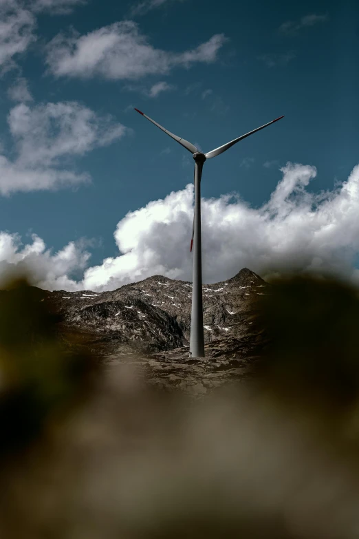 a wind turbine stands on top of the land