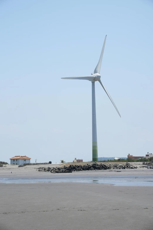 an old windmill sits in the sand next to the ocean