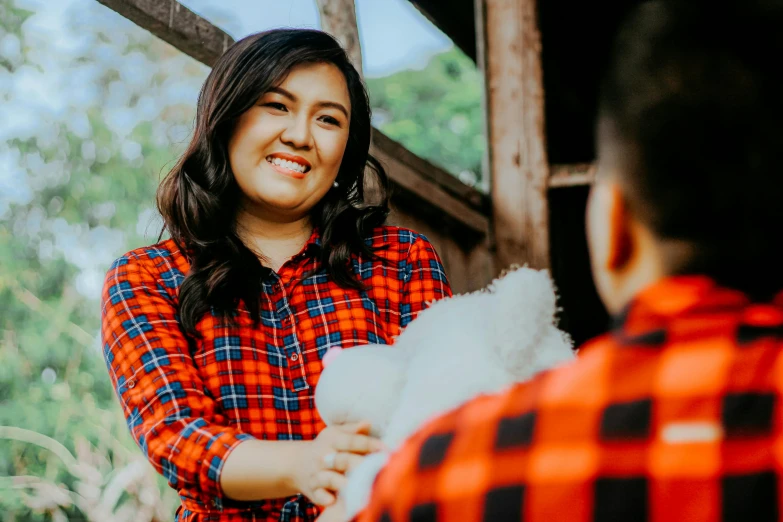 an asian woman is giving a man soing