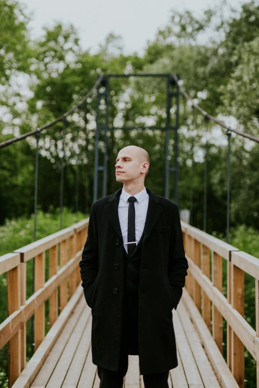 a man in a long coat and black tie