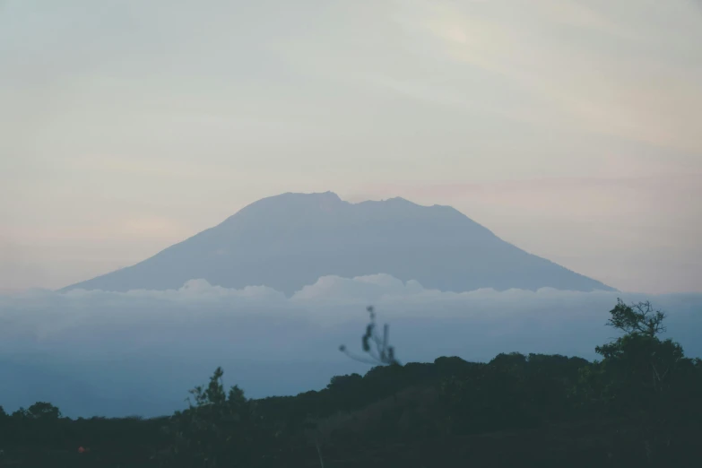 the view of a hill that is covered in clouds