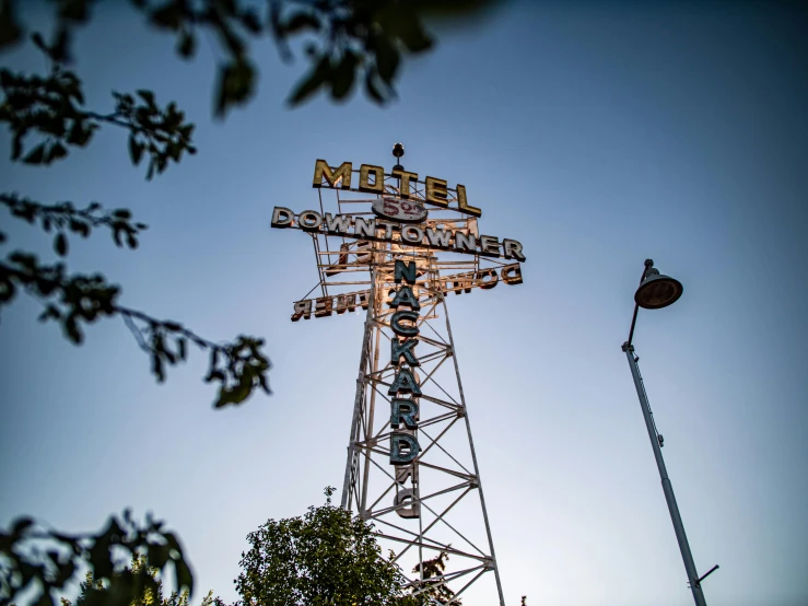 a large sign sitting on top of a tower next to trees