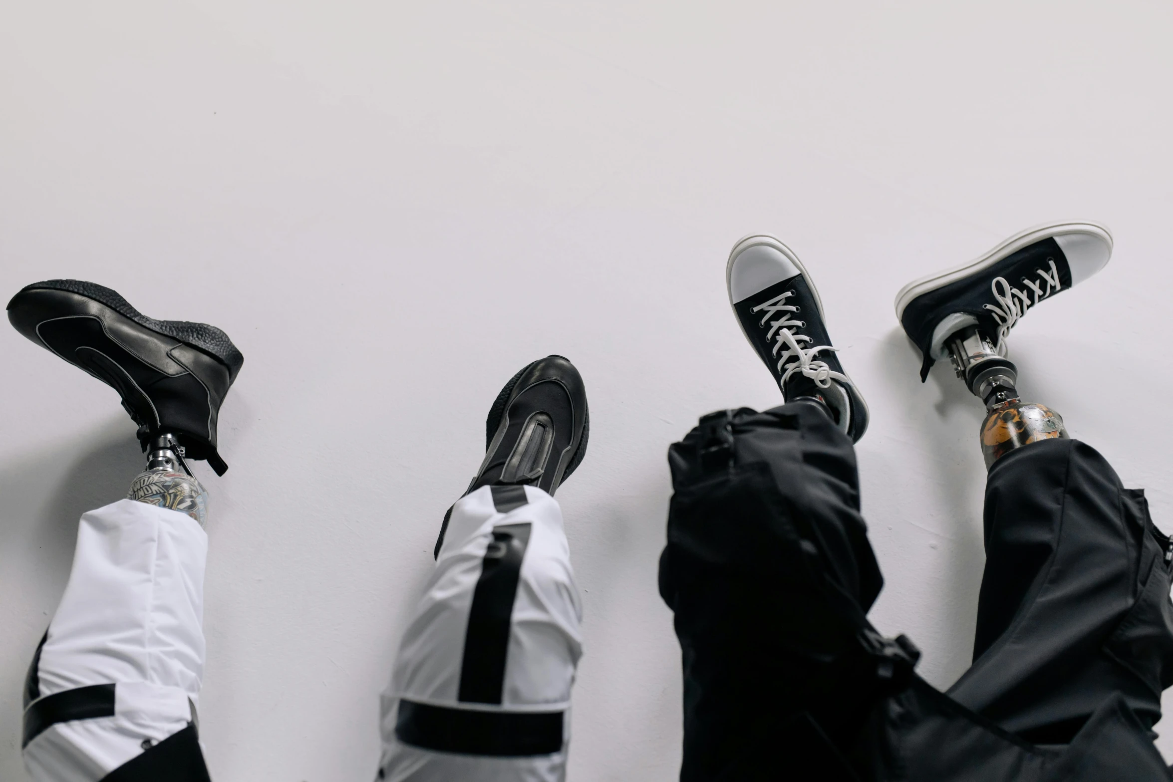 three people lay down in their own black and white outfits