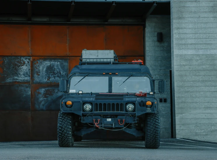 a large army vehicle parked next to an empty garage