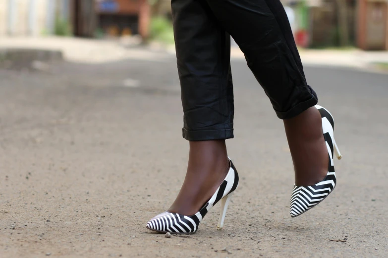 a person in black pants and white shoes with ze striped shoes