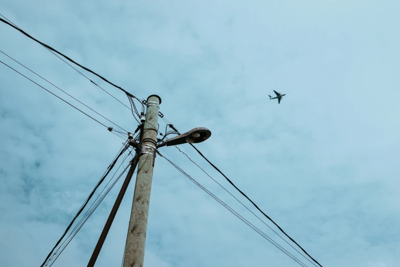 an airplane flying above power lines under the blue sky