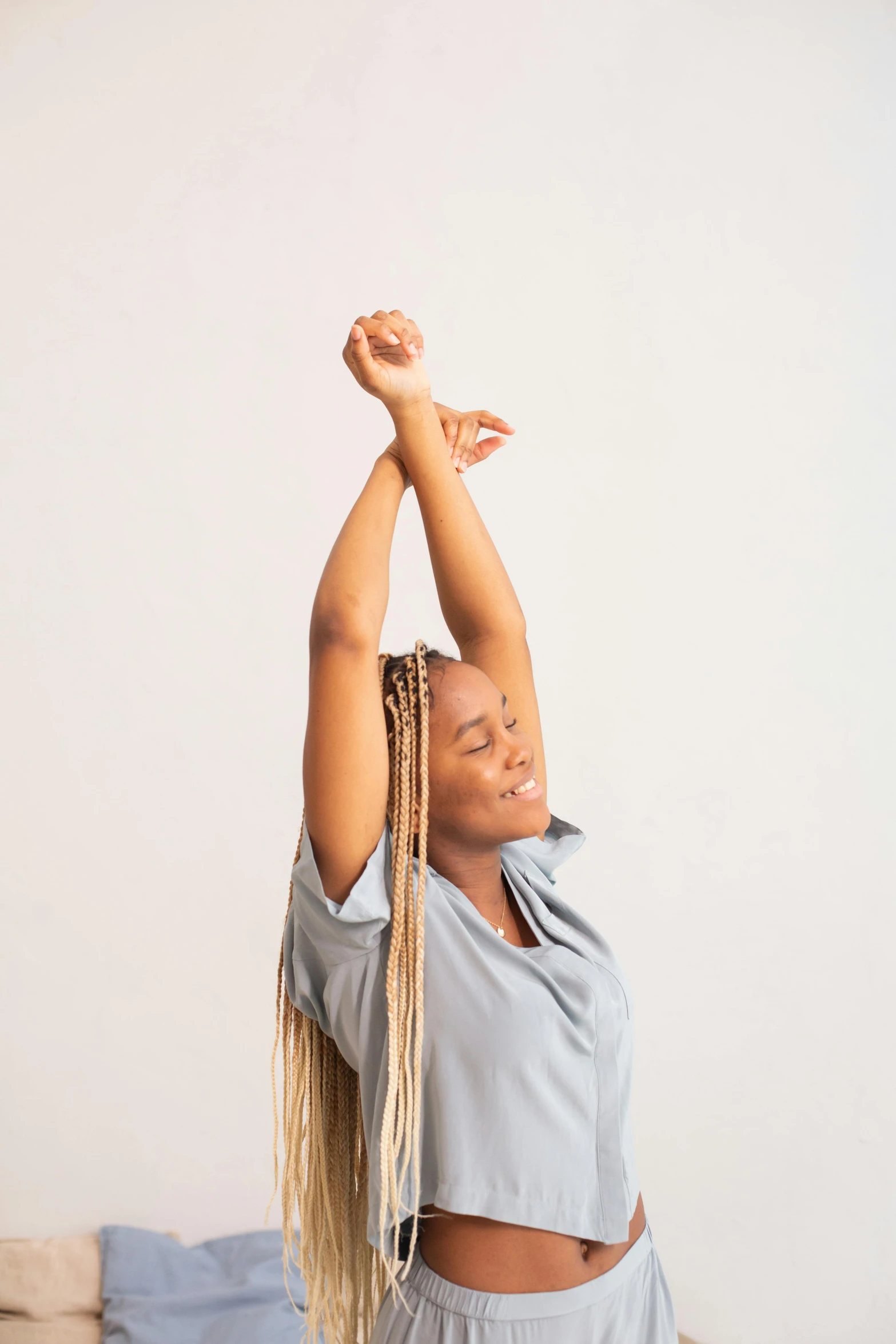 a woman with blonde hair standing in the air in a yoga pose