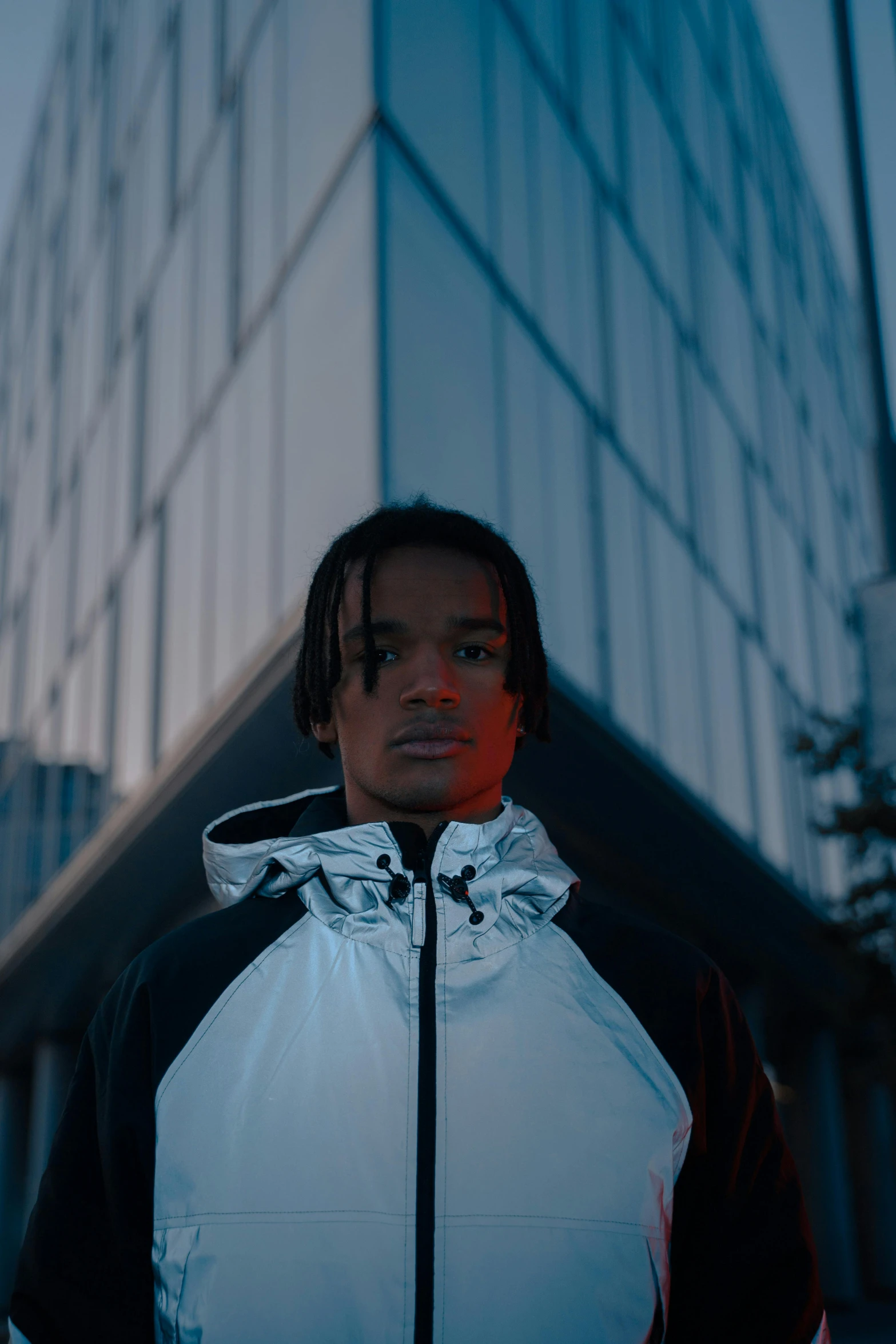 a man with dread locks and wearing a white jacket