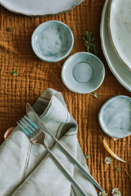 a fork rests in the center of a table that has white dishes