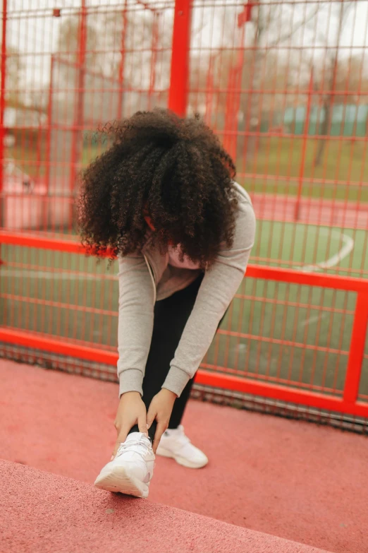 a woman is bending down while stretching her legs