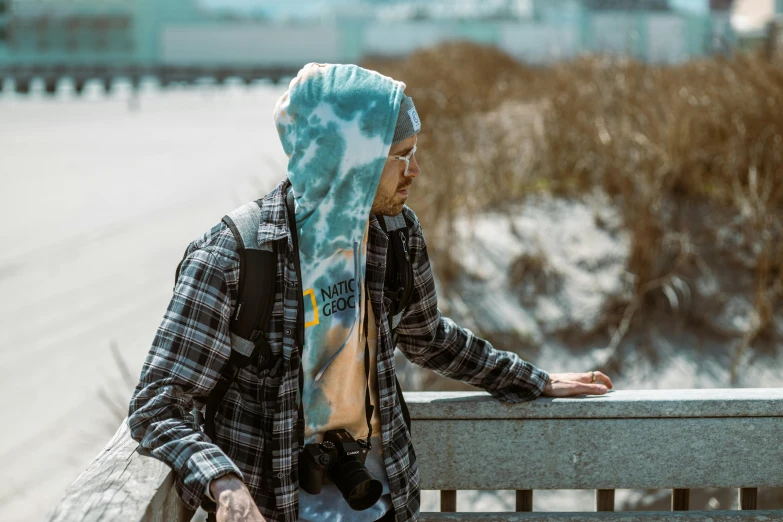 the man is wearing a head covering standing on a bench