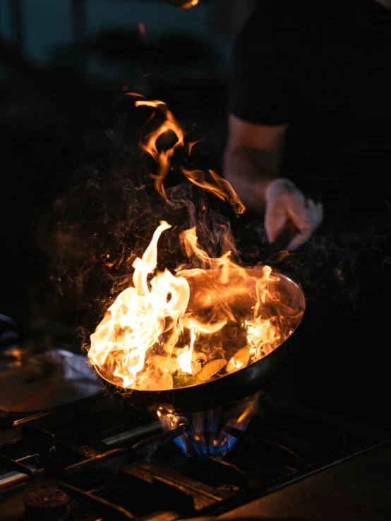 flames are being used to roast vegetables in an oven