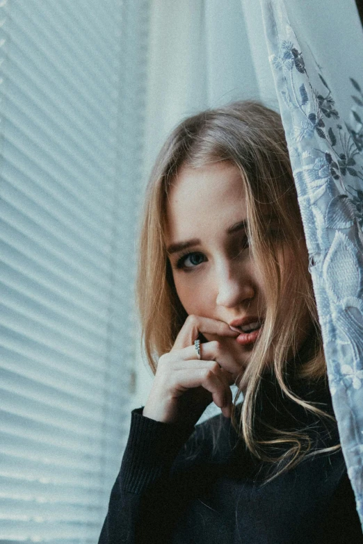 a woman that is standing under a curtain