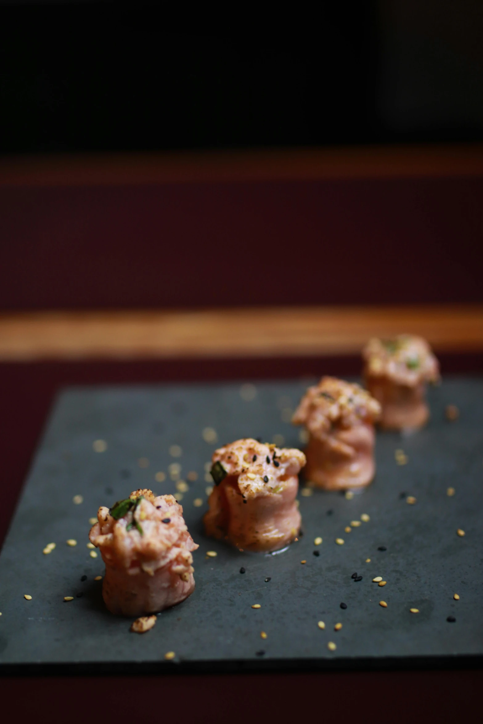 five little snacks on a dark plate