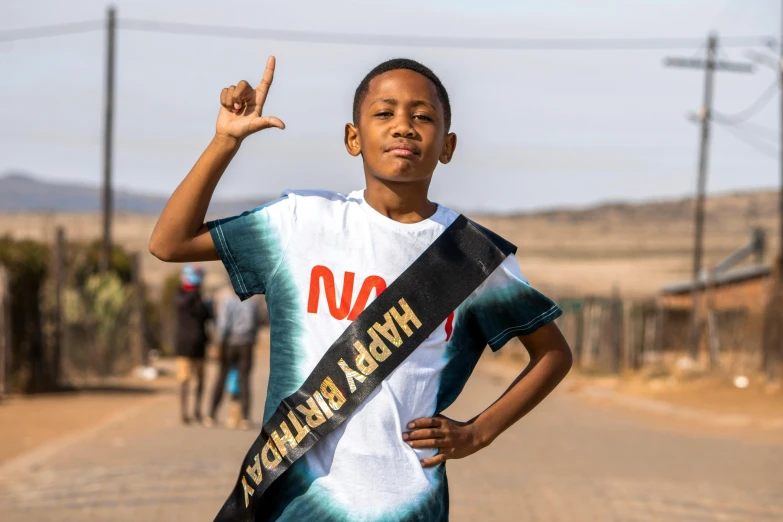 a boy holding a ribbon in his left hand