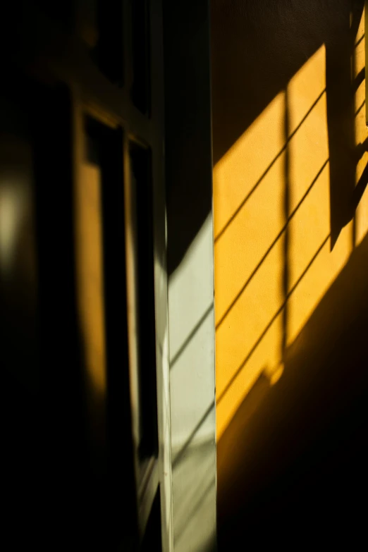 the shadows of the door, outside a building, reflect on a wall