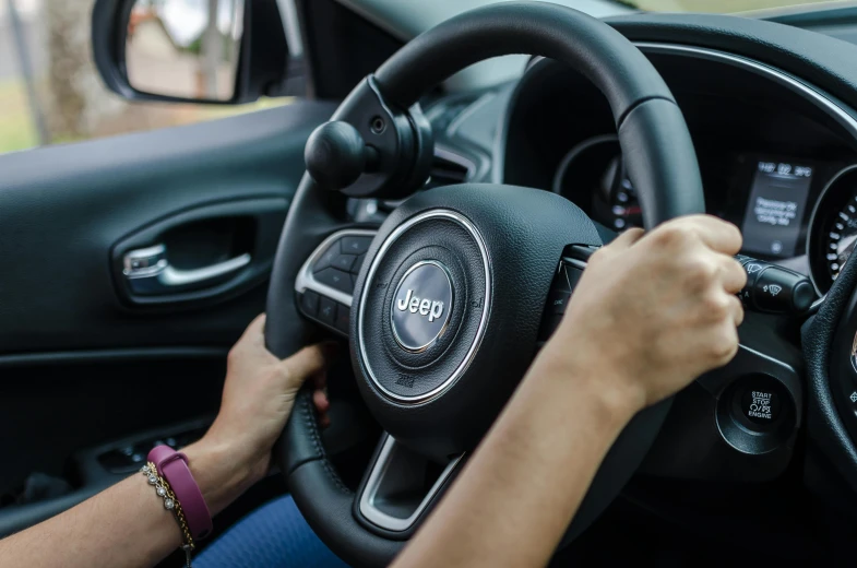 someone's hands on the steering wheel of a car