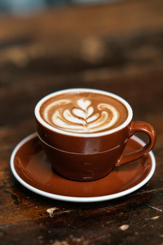 an elegant espresso on a brown plate sits upon a wood table