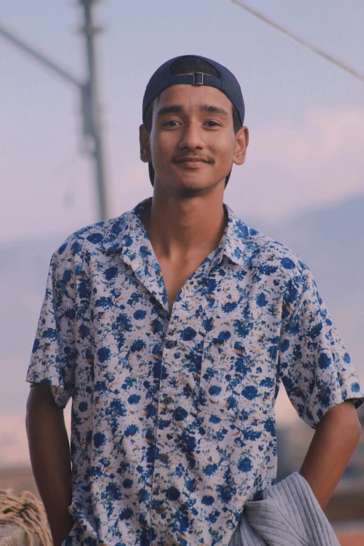 a young man standing by himself next to power lines