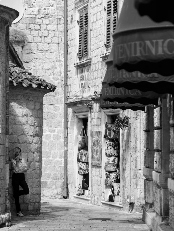 man sitting in doorway of stone building outside with umbrella