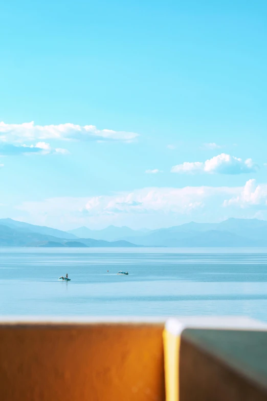 a bench is facing the sea and mountains