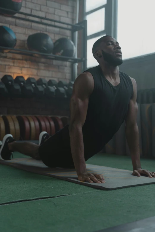 a man in a black tank top doing a handstand exercise