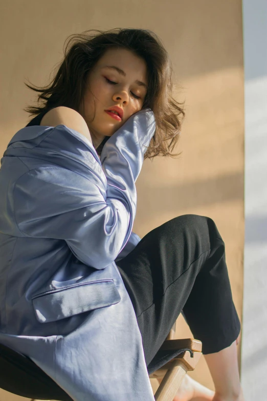 a woman is sitting on a ledge holding her head