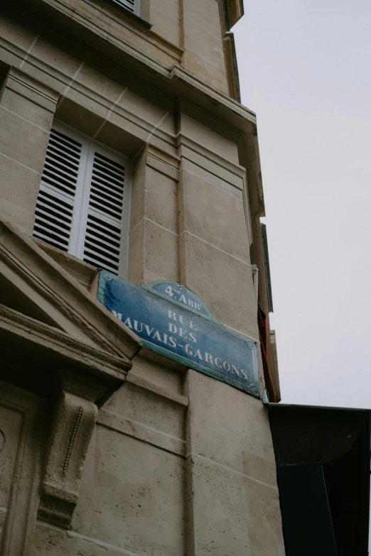 an old, broken down building with a sign and a weather vane