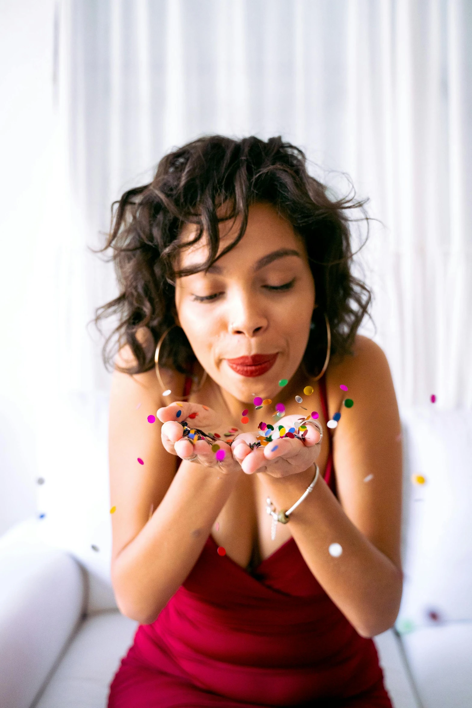 a girl is holding confetti and smiling