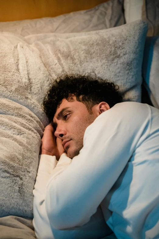 a man laying in bed looking at his phone