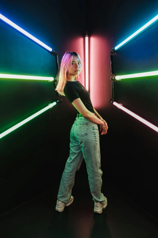 a woman wearing white sneakers is standing in front of colorful lights