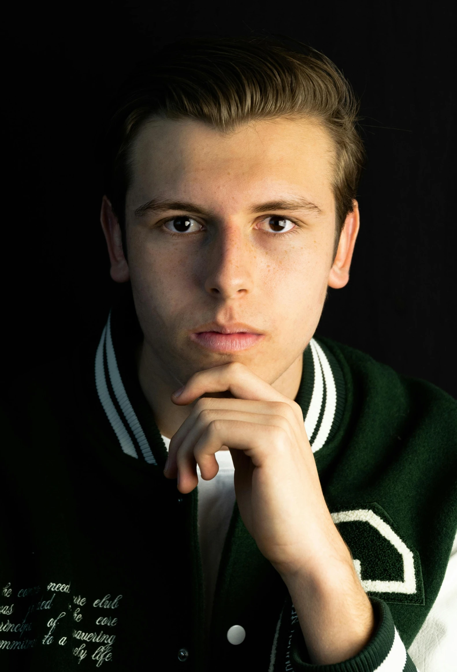 a young man with a green and white jacket posing for a po