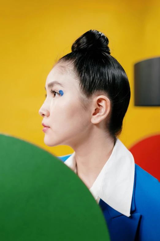 a woman in an orange and blue top is holding a green umbrella