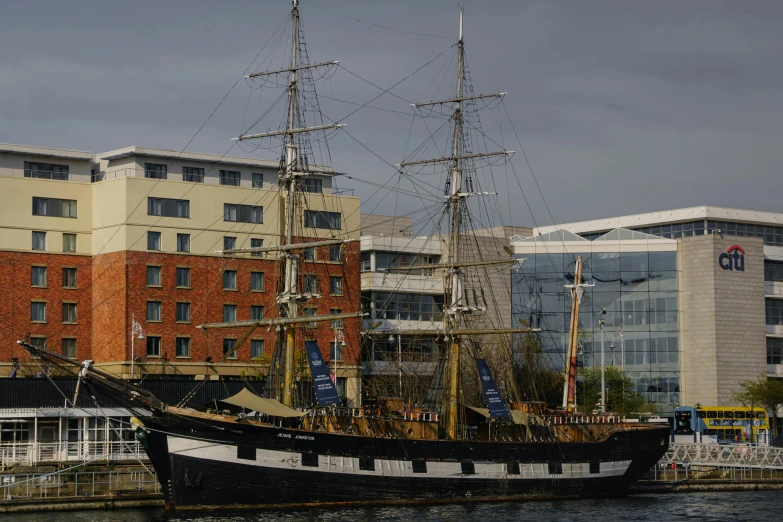 a big black and white ship docked in front of buildings