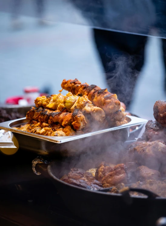 food cooking on grill next to a person