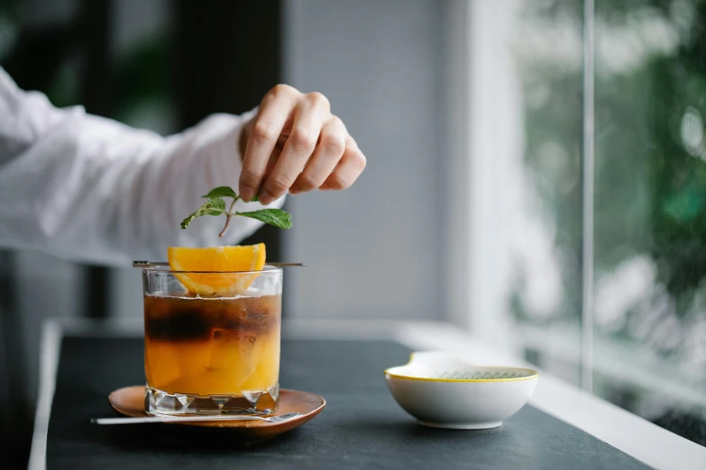 a person is adding a garnish to a cocktail