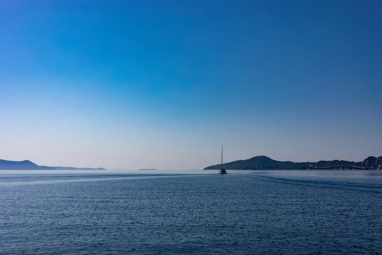 the ocean with blue sky and island in the background