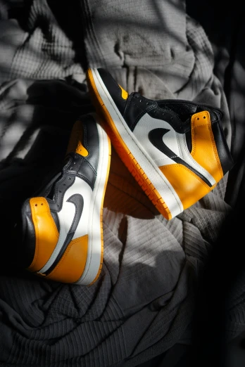 two pairs of shoes are shown with one yellow and white nike sneaker
