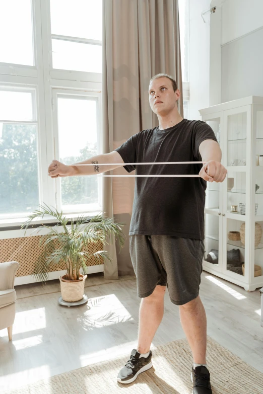 a man is standing in the living room and holding a white pole