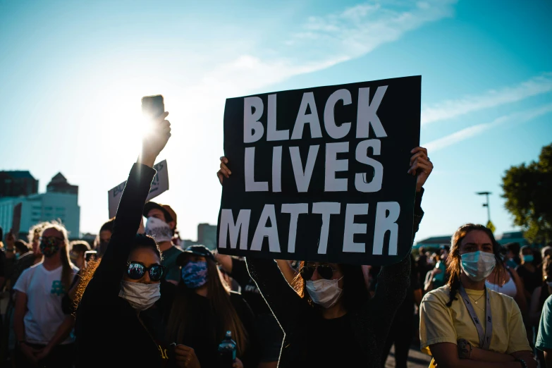 protestors hold signs reading black lives matter