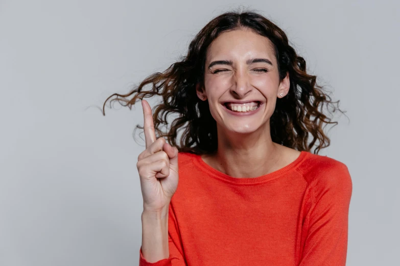 a beautiful woman smiling holding her fingers up